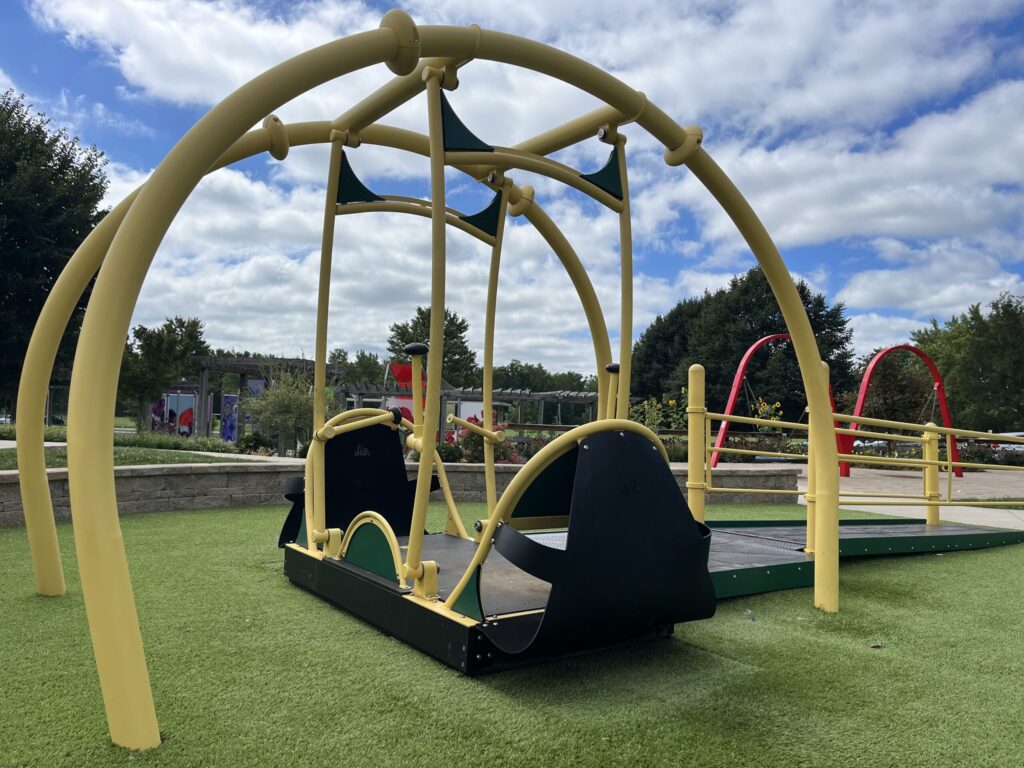A playground with swings and slides on the grass.