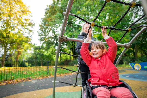 A girl in a wheelchair on the playground.