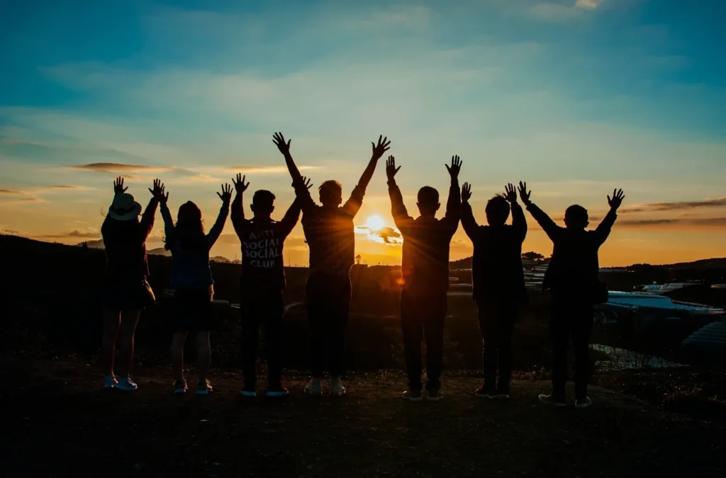 A group of people standing in front of the sun.