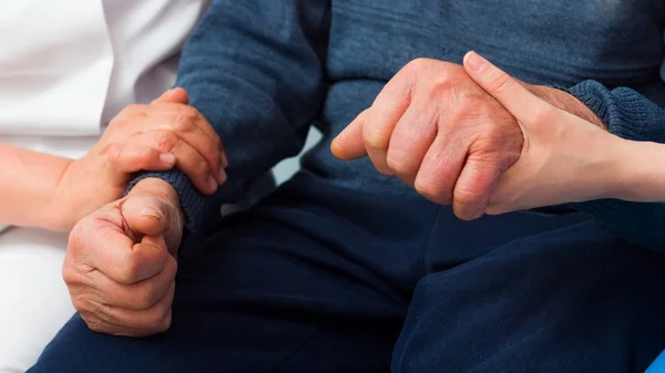 A man sitting down with his hands crossed.